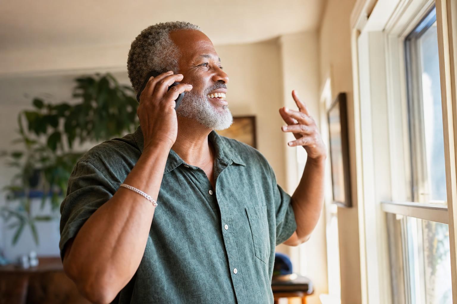 Older man answering a phone call at home in the morning
